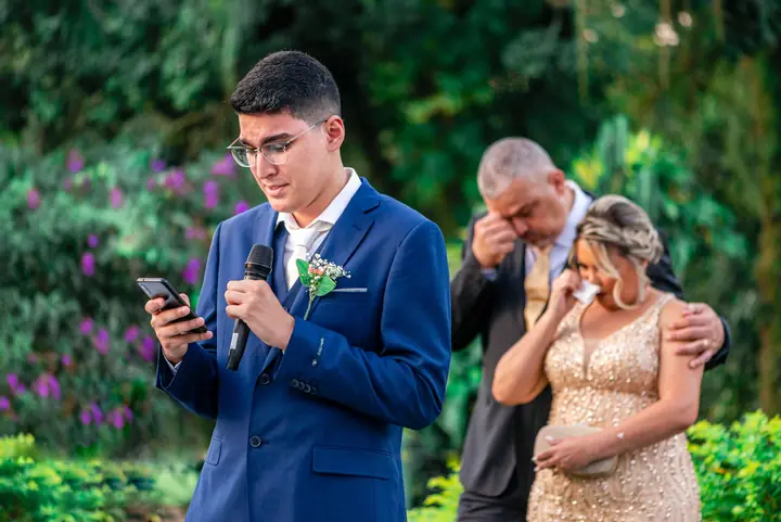 Noivo lendo os votos emocionado, com a noiva e o pai chorando ao fundo