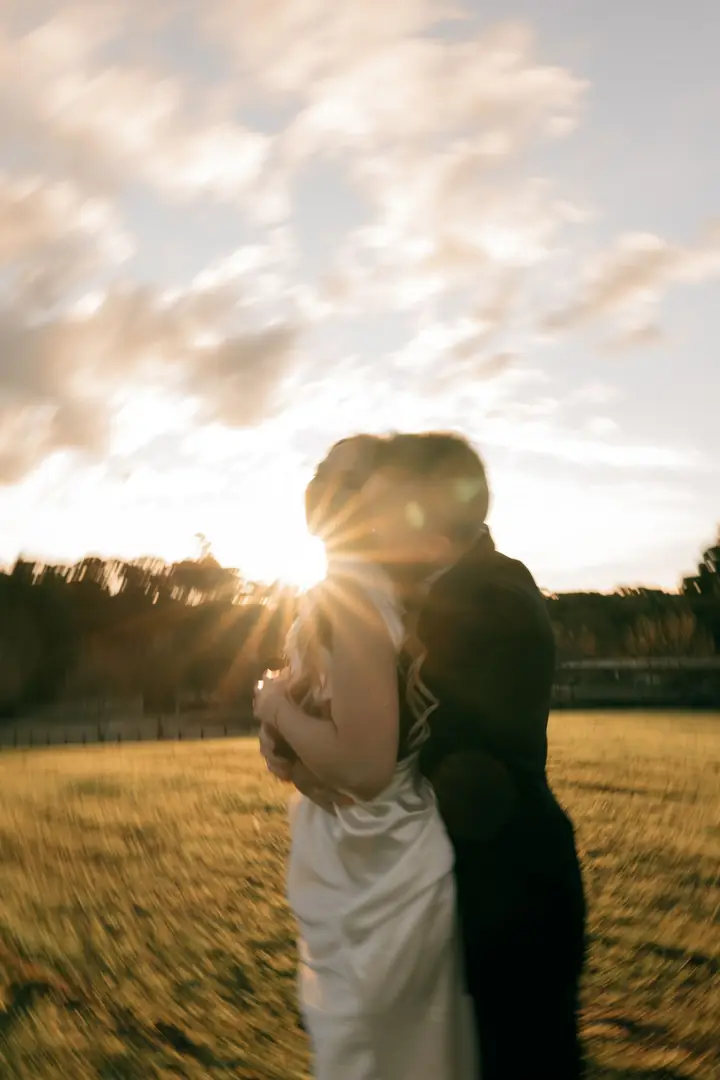 Casal abraçado com o sol passando entre os dois